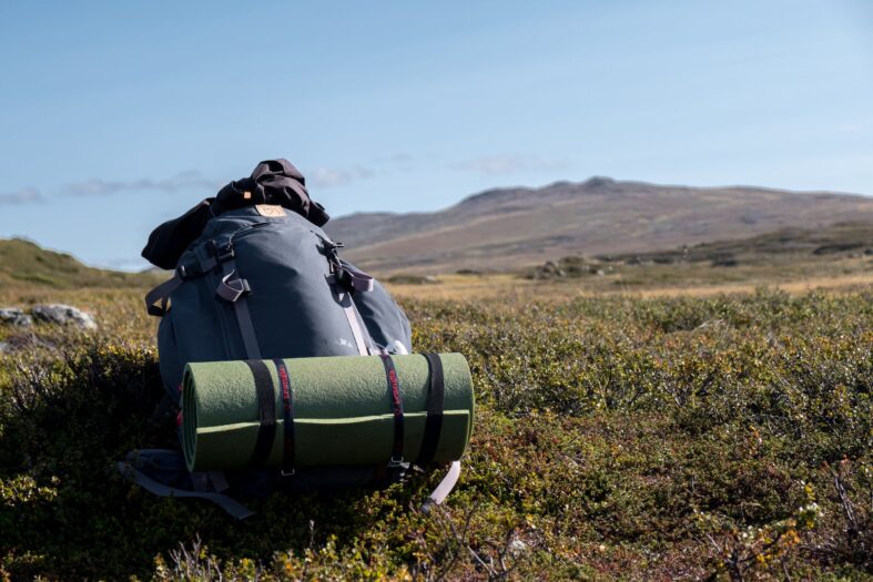 big backpack with mat on a grass field